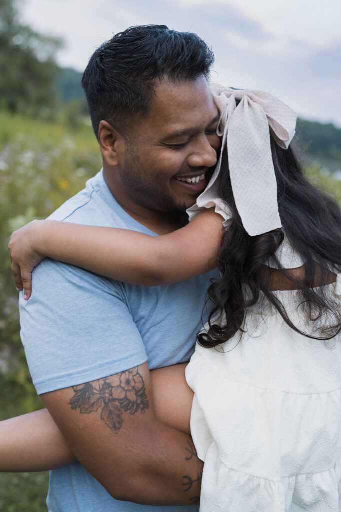 Father laughing as he holds daughter