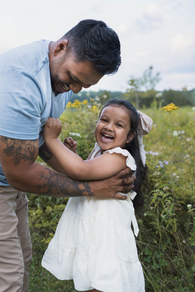 Girl smiling as father lets her down from being thrown in the air