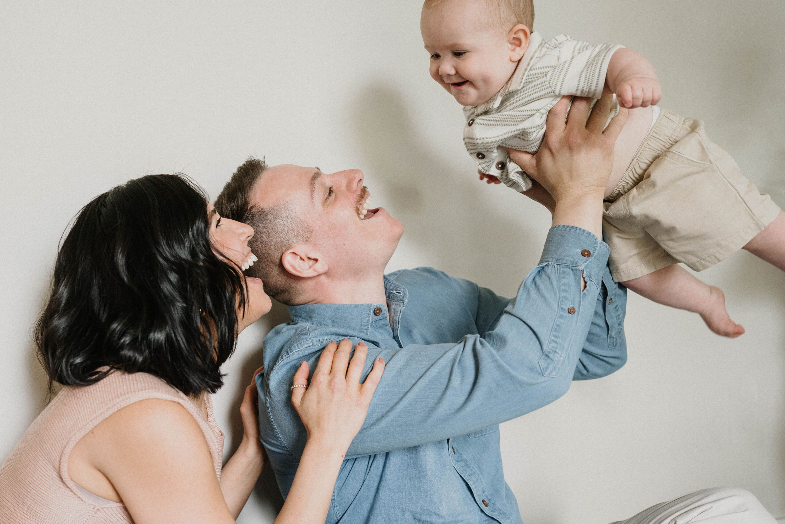 mom and dad doing airplane with baby