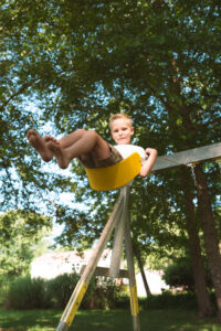 Boy swinging at home in Edmond Oklahoma family photography session