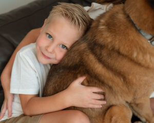 Boy snuggling a dog during in-home Oklahoma City lifestyle photography session