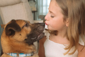 Girl kissing dog in Oklahoma City in-home family photography session